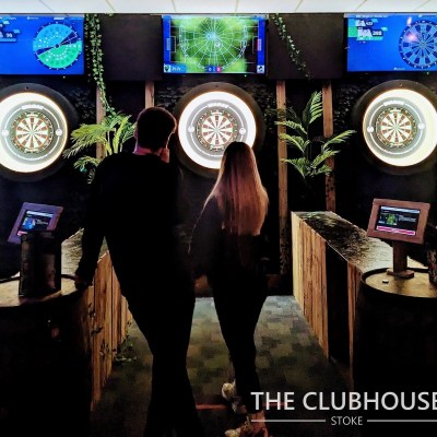 a group of people standing in front of darts board