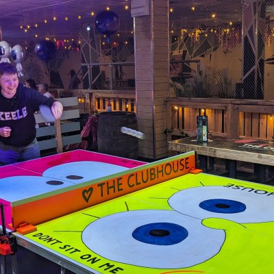 a group of people sitting at a table with a birthday cake