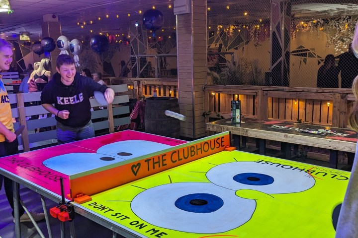 a group of people sitting at a table with a birthday cake